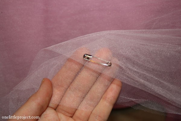 Using safety pins to keep the tulle in place