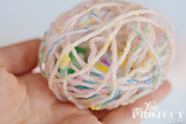 DIY Yarn Eggs - Dip the yarn in glue and it hardens over the balloon and the chocolate treats stay neatly inside!