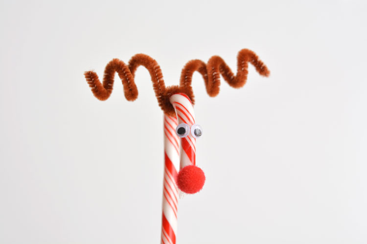 Candy cane decorated to look like a reindeer.