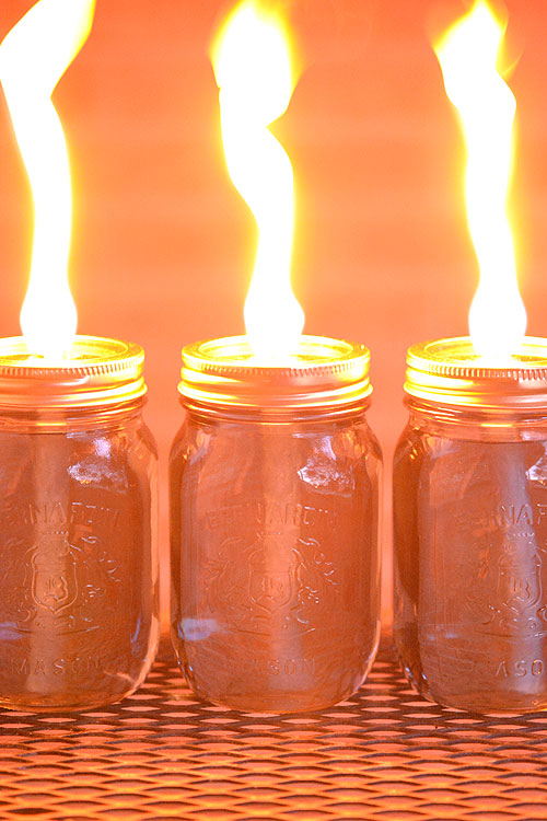 These mason jar citronella candles are REALLY EASY and they really keep the bugs away! What a fun and beautiful summer project! Those flames are amazing!