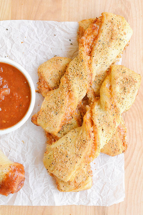 These twisted pizza breadsticks are delicious and they're so easy! They're loaded with cheesy pizza goodness! They make an impressive appetizer or snack and only take about 20 minutes to make.