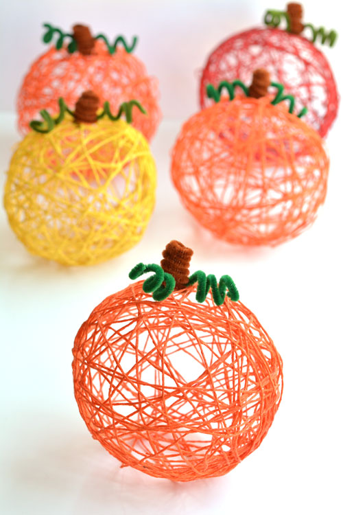 DIY yarn pumpkins on a white background
