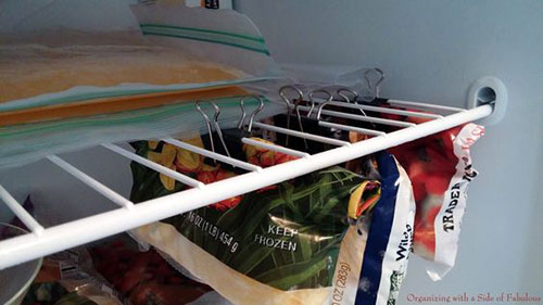 25 Hacks to Organize your Fridge - Use binder clips to hang bags of frozen fruits and vegetables in the freezer