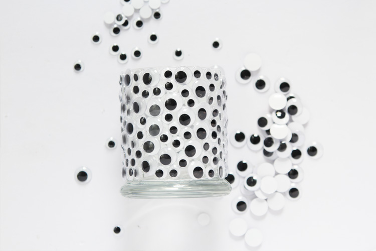 Add some googly eyes to a glass candle holder for the easiest and most ADORABLE Halloween decor!