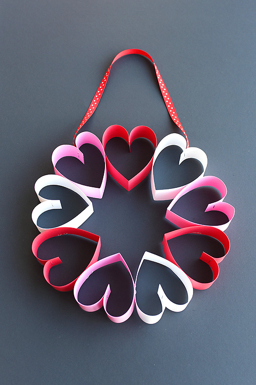 This stapled paper heart wreath is such a fun and EASY Valentine's Day craft to make with the kids! It's a great little wreath to hang on a bedroom door (or school classroom door?) and it makes a super cute and simple Valentine's decoration!