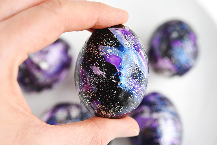 These galaxy Easter eggs made with nail polish and glitter are SO COOL and crazy fun to make! This is such a fun Easter craft to try and a totally different way to decorate your Easter eggs! Each one is completely unique and beautiful! Such a great galaxy craft and a stunning idea for Easter decorations!
