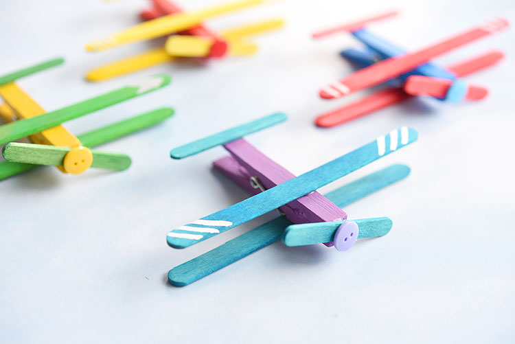 These clothespin airplanes are SO CUTE and they're really easy to make using clothespins and craft sticks (popsicle sticks). This is such a fun kids craft and a great craft for a rainy day! They look like real airplanes and the clothespins even open and close! 