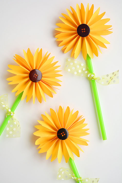 These folded paper sunflowers are SO PRETTY! And they're so easy to make! This is such a great craft project for summer or would even make a great fall craft! I love the button in the middle!