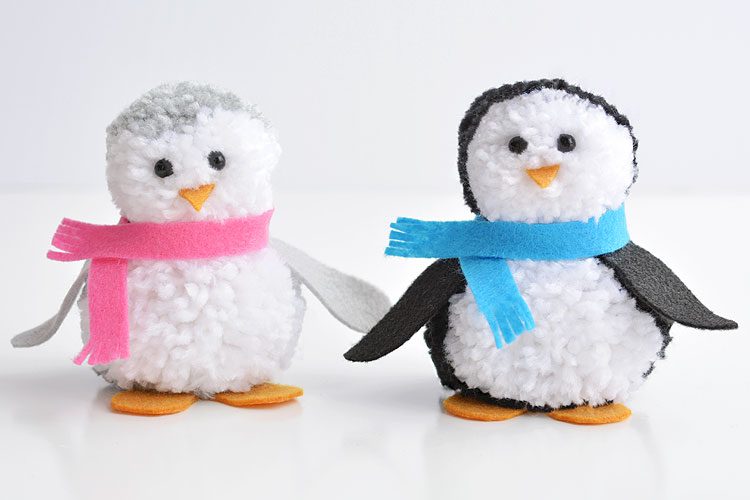 Two pom pom penguins standing beside each other