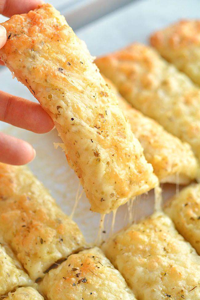 These cheesy garlic breadsticks are so easy to make and they taste SO GOOD! They take less than 20 minutes from start to finish and go really well with your favorite soups and salads. You can even serve them on their own with a little bowl of marinara sauce. This is such an easy, awesome and super delicious side dish recipe that uses Pillsbury refrigerated pizza crust. 
