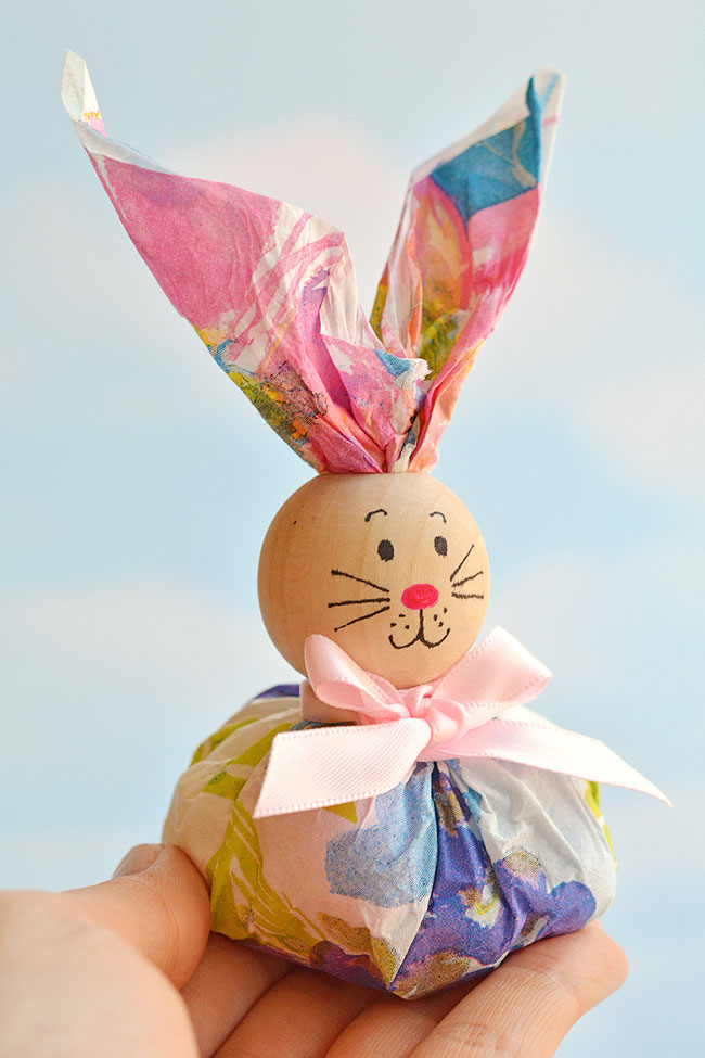 These paper napkin bunny favors are SO CUTE! And they're really easy to make! With dollar store paper napkins and foil covered chocolate eggs you can make adorable Easter treats to give away to the kids, grandkids or even to the classroom at school! They'd even make super cute decorations for the Easter table. This is such a fun and simple Easter craft idea.