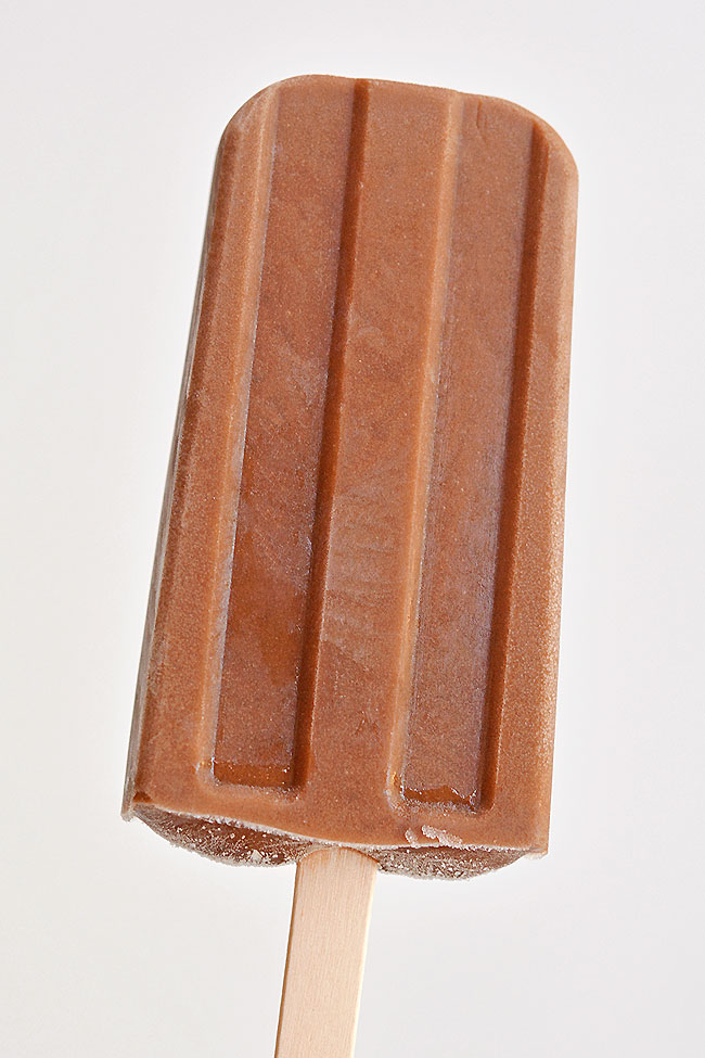 Homemade fudgesicle held against a white background