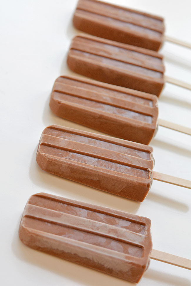 A line of homemade fudgesicles sitting on a white background