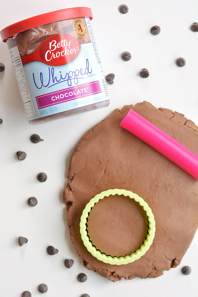 This edible chocolate play dough made with chocolate frosting is SO FUN and it's so simple - you only need 2 ingredients! The dough feels just like regular play dough and it's completely safe (and delicious!) to eat. You can use your favourite play dough tools and have a little snack while you're playing. This is such a fun kids activity and a super easy play dough recipe!