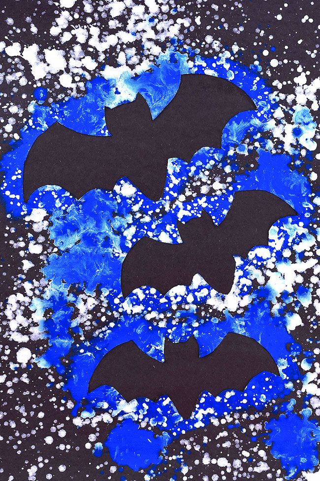 This splatter paint bat artwork is SO FUN to make! Using dollar store spray bottles and washable paint you can quickly make really awesome silhouette artwork of bats in the night sky! This is such a fun craft for kids and a great Halloween project! Such a fun way to learn about negative space at home or in the classroom.