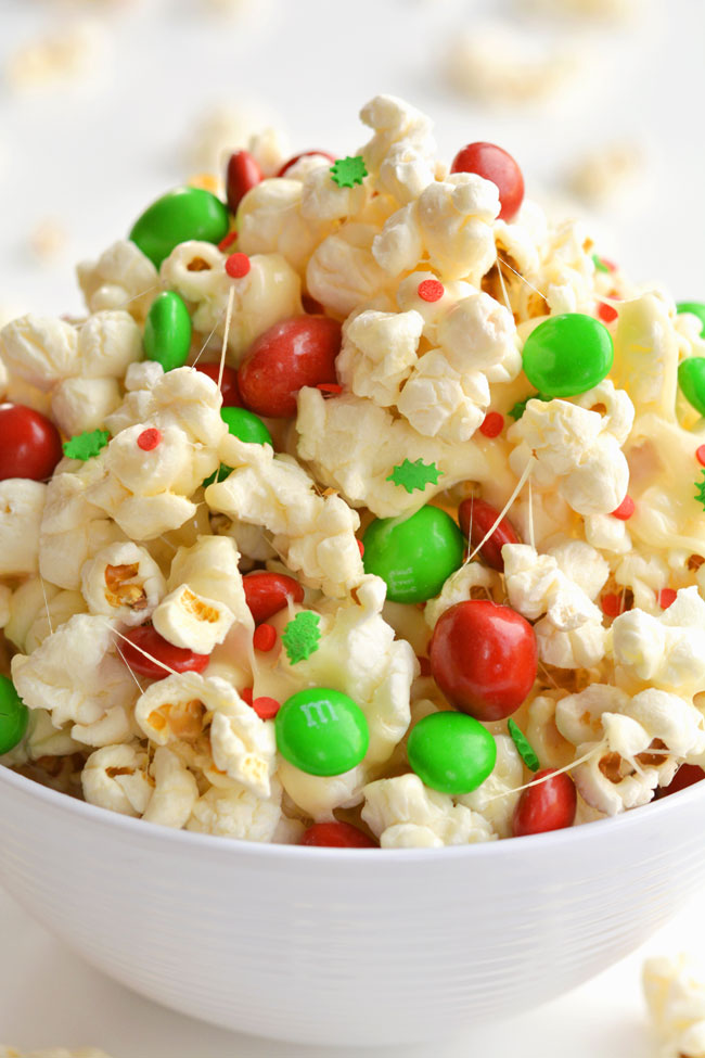 This marshmallow Christmas popcorn is SO GOOD and it's really simple to make. Such a great Christmas treat idea for kids and grown ups! I've also seen it called Santa Crunch Popcorn. Who knew marshmallow popcorn was a thing!? Top it with sprinkles and M&M's and this sweet and salty popcorn is delicious! (And perfect for the holidays!)