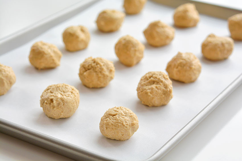 Balls of peanut butter cookie dough on baking tray