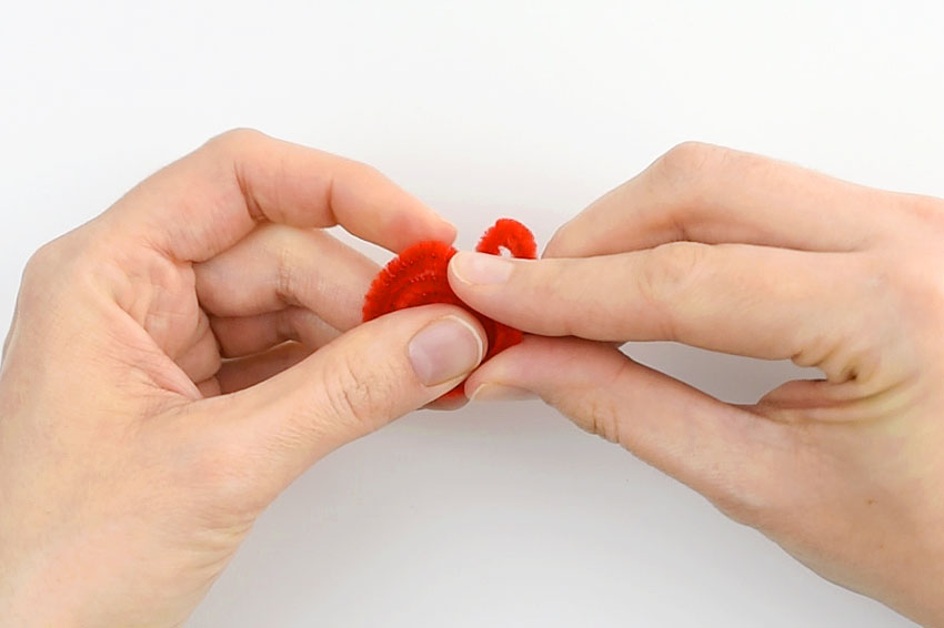 Pipe cleaner spiral being shaped into the bottom of a heart