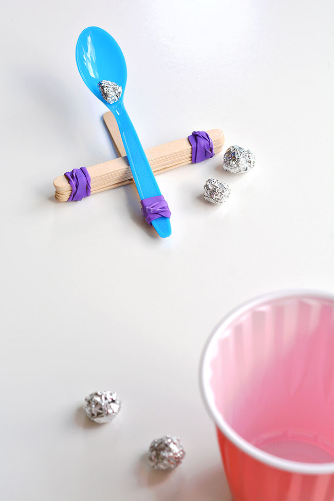 Popsicle stick catapult with tin foil balls, aimed at a cup