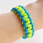 Green and blue paracord bracelet worn on a wrist