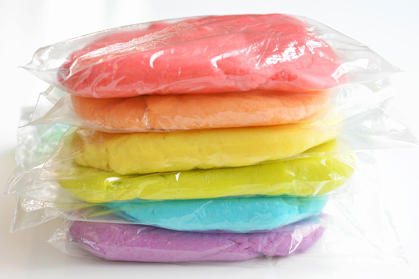 6 baggies of coloured playdough, flattened and sitting on top of each other