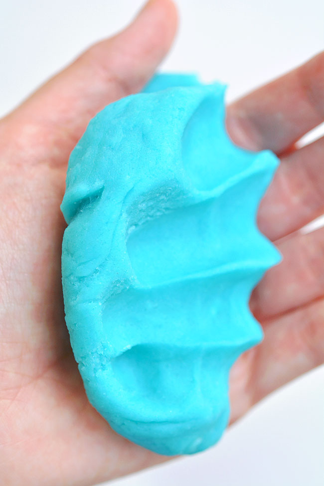 Blue playdough squished and held in a hand