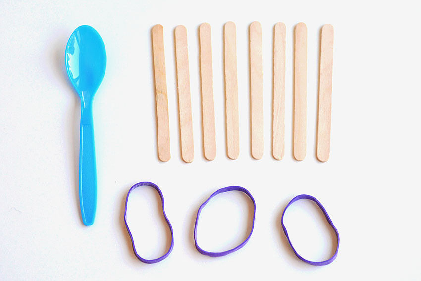 Supplies for a popsicle catapult, sitting on a white background
