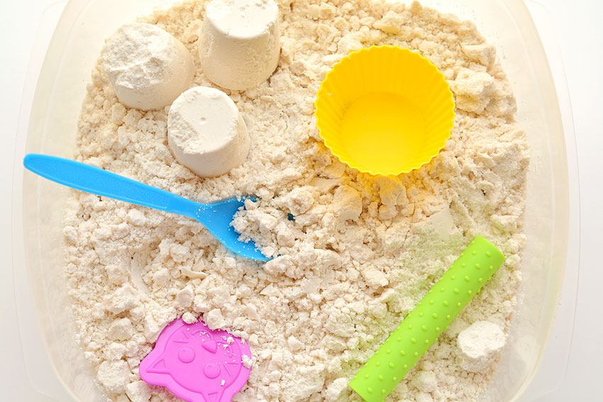Moon sand in container with colourful toys
