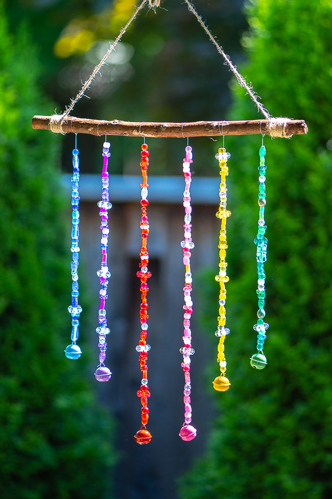 Rainbow coloured DIY wind chimes hanging outside