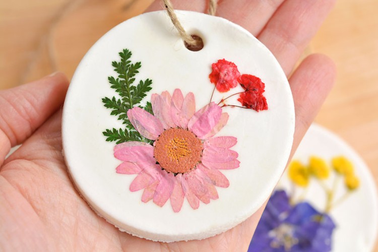 Pressed flower ornament held in someone's hand