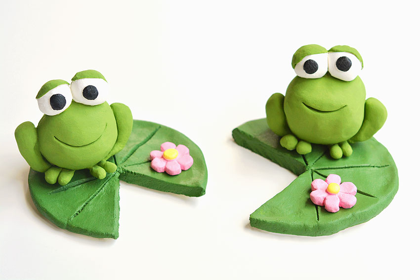 Two clay frogs sitting on their lily pads