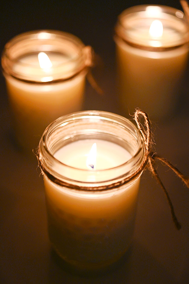Three DIY mason jar candles burning