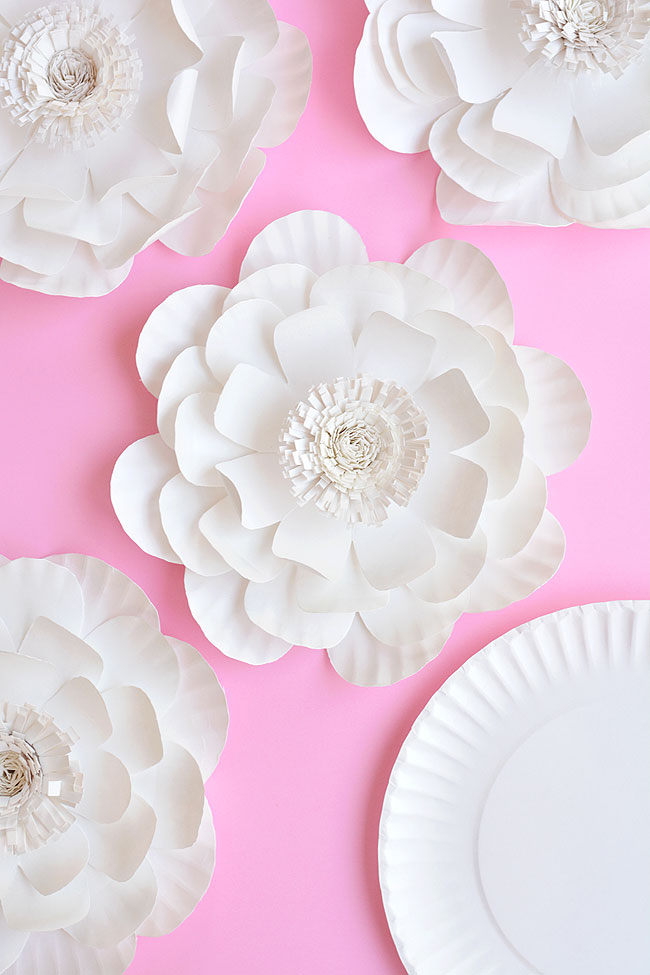 A group of paper plate flowers on a pink background