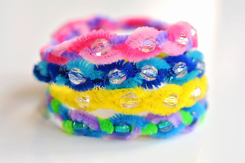 A pile of different colored pipe cleaner bead bracelets