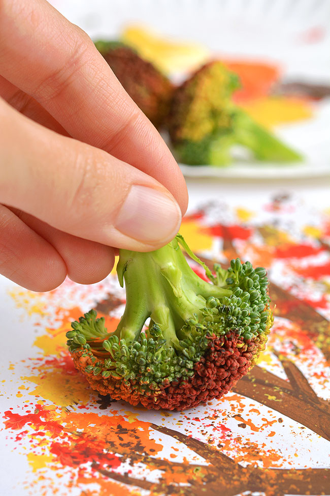 Using broccoli to paint fall leaves on a tree