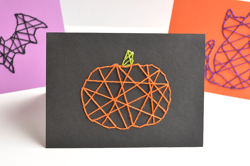 A pumpkin Halloween string art card centered in frame