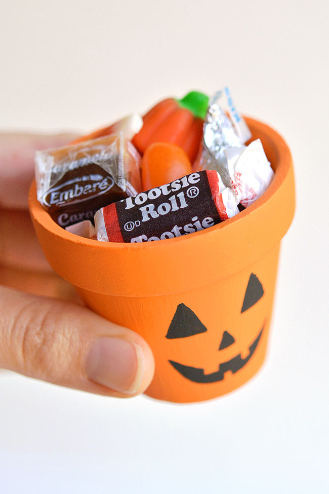Jack-o-lantern painted clay pot filled with candy