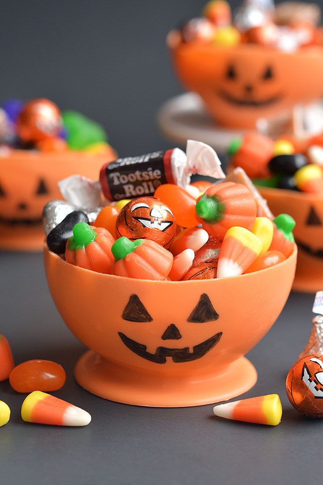 Edible jack-o-lantern bowls overflowing with candy