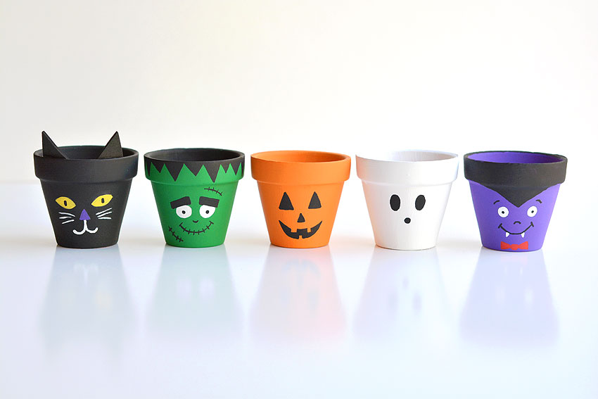Halloween clay pots painted like a black cat, Frankenstein, jack-o-lantern, ghost, and vampire