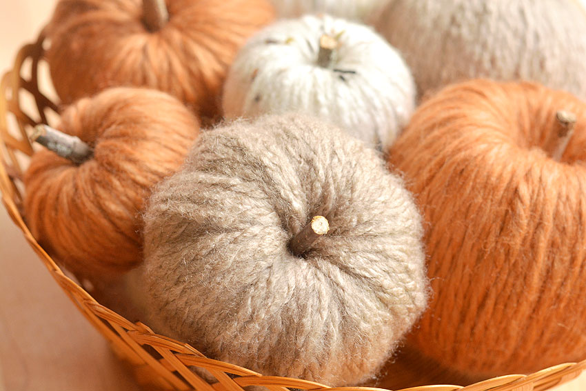 Three colours of yarn pumpkins in a wicker basket