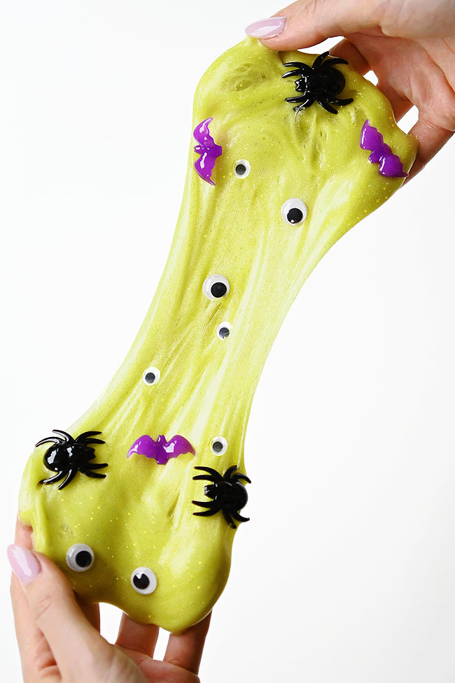 Green Halloween slime filled with googly eyes, bats, and spiders
