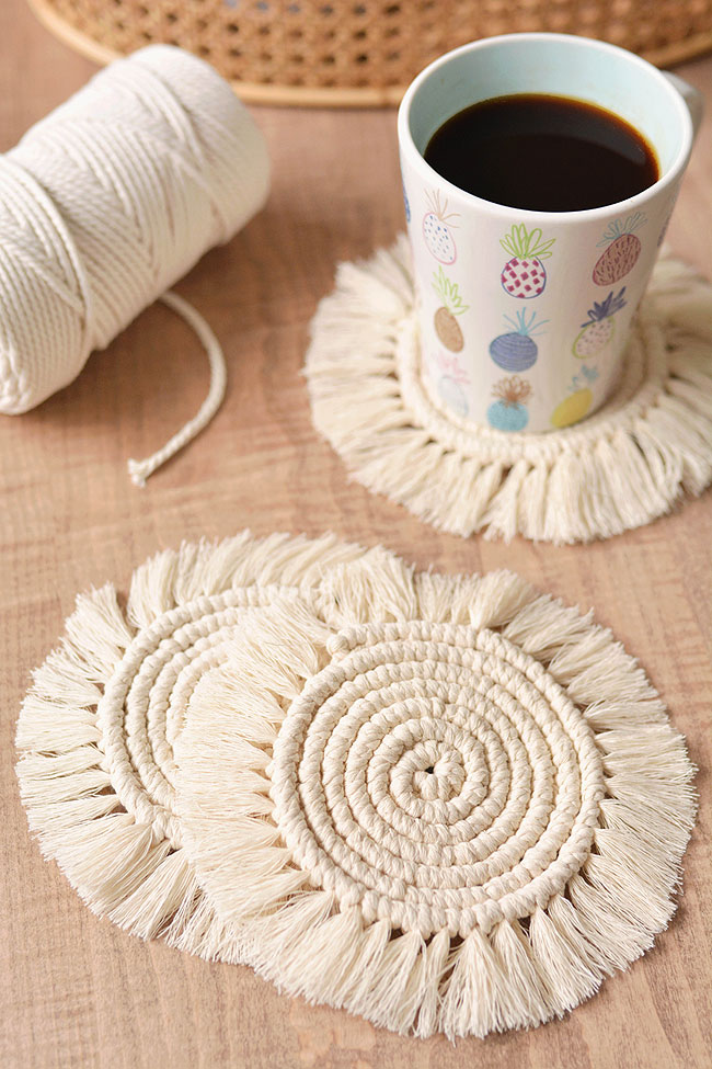 Macrame coasters with cord and a coffee mug in the background