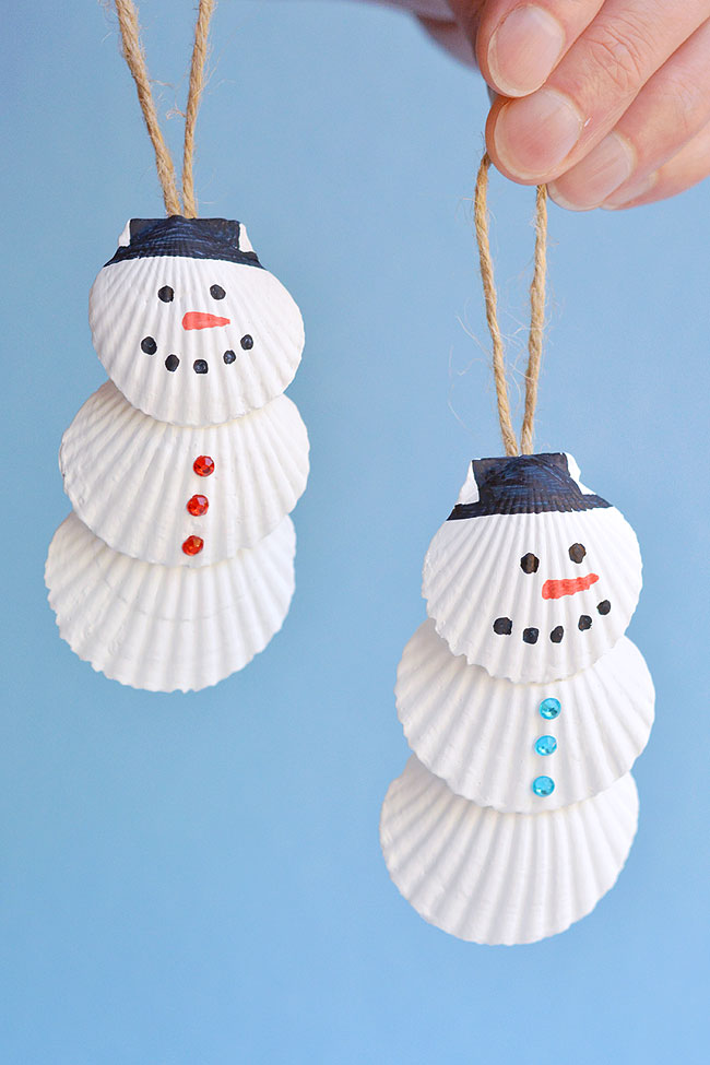 Two snowman seashell ornaments, with blue and red rhinestone buttons