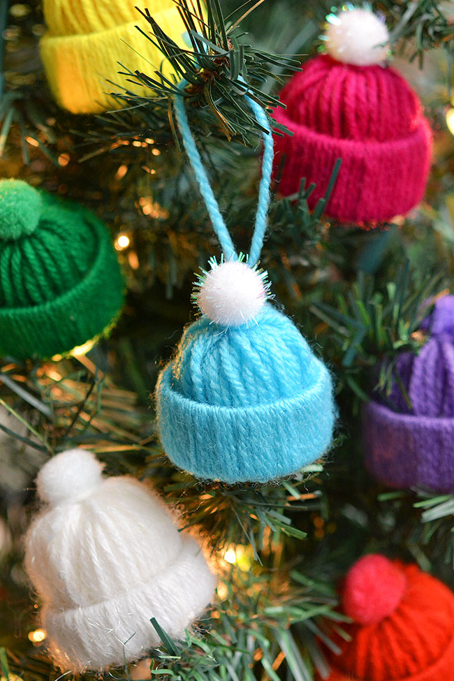 Colourful yarn hat ornaments on a Christmas tree