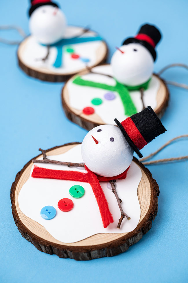 Melting snowman ornaments made on a wood slice