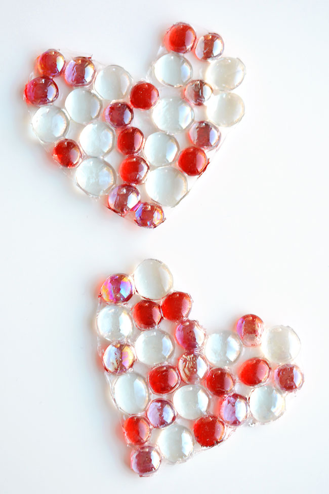 Two heart shaped glass bead suncatchers on a white background