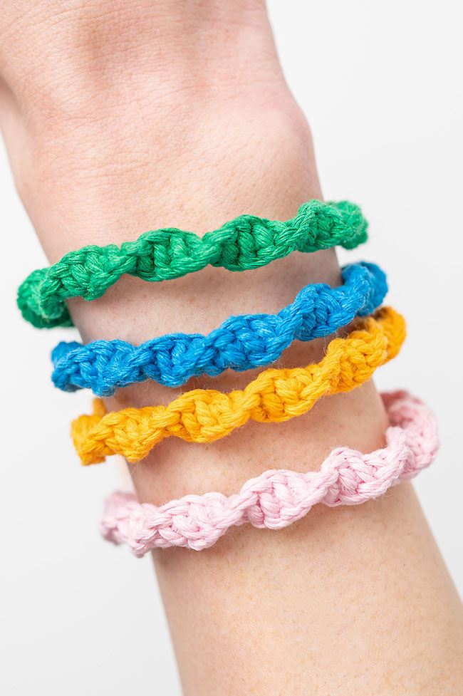 Spiral stitch macrame bracelets in green, blue, yellow, and pink