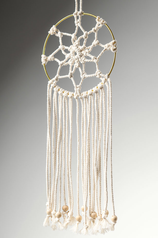 Side angle of a macrame dream catcher hanging up