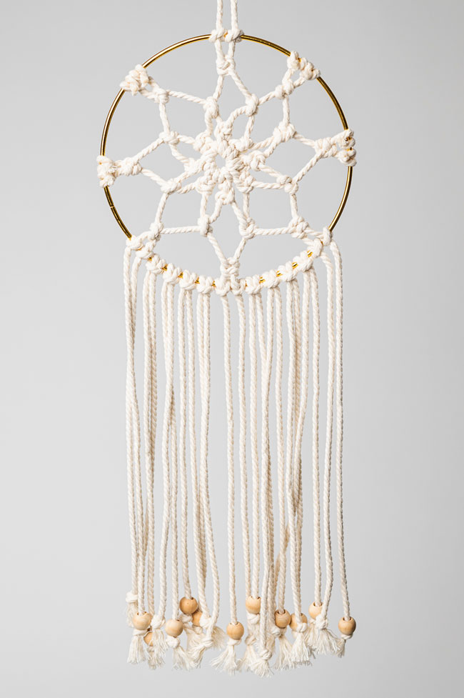 Macrame dream catcher on a gold hoop with wooden beads