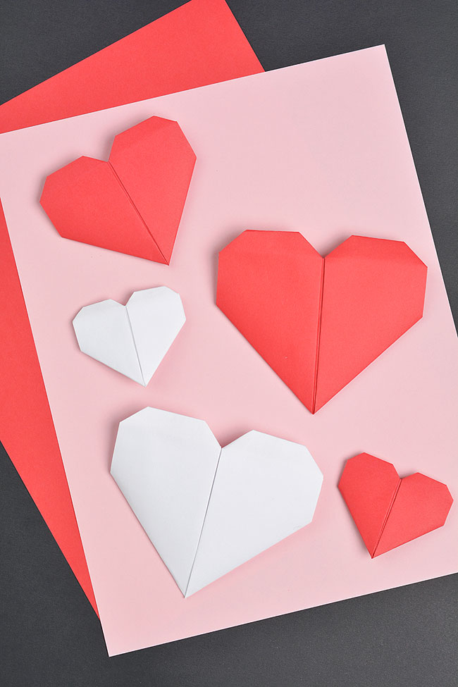 A group of paper hearts sitting on coloured paper